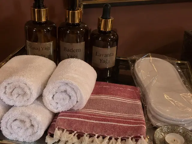 Masaj yağları, rulo havlular, kırmızı çizgili peştemal ve terlik — Asmalı Mescit, Masaj Salonun